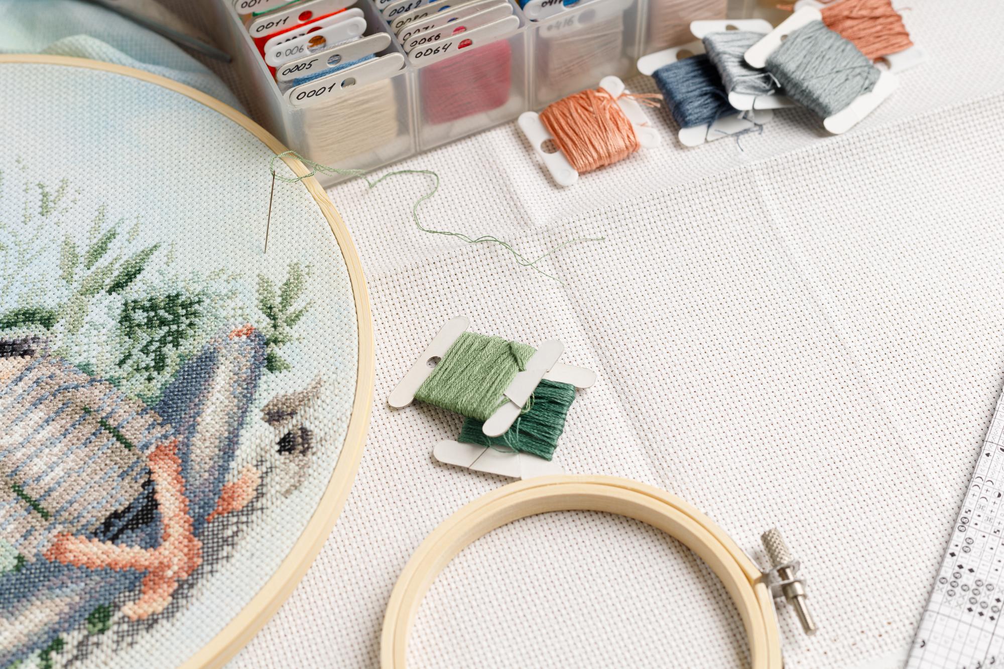Atelierarbeitsplatz mit Stickrahmen und Garnrollen